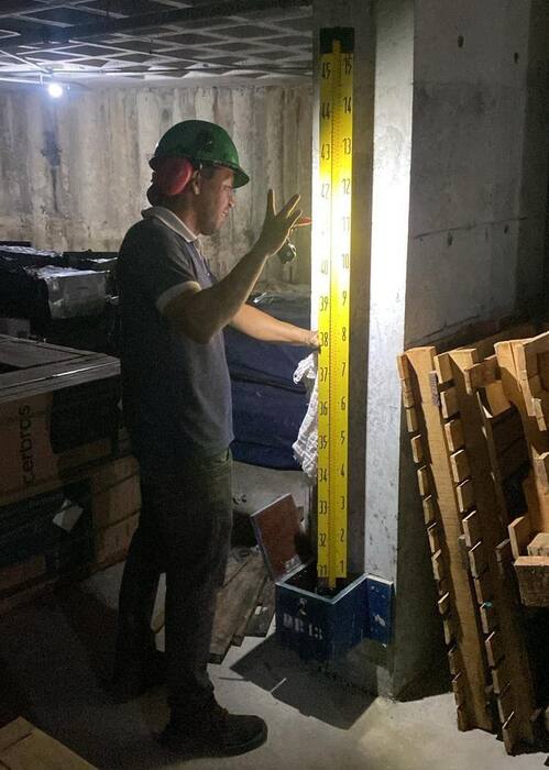 Técnico posicionando a mira de nivelamento em um pino de recalque